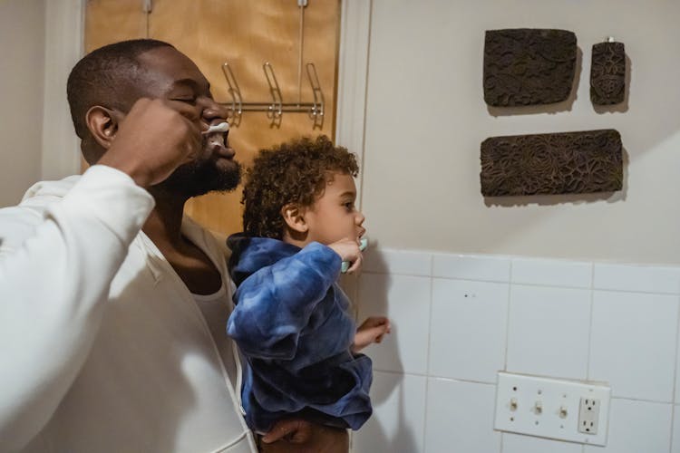 Black Father And Son Brushing Teeth During Morning Procedure