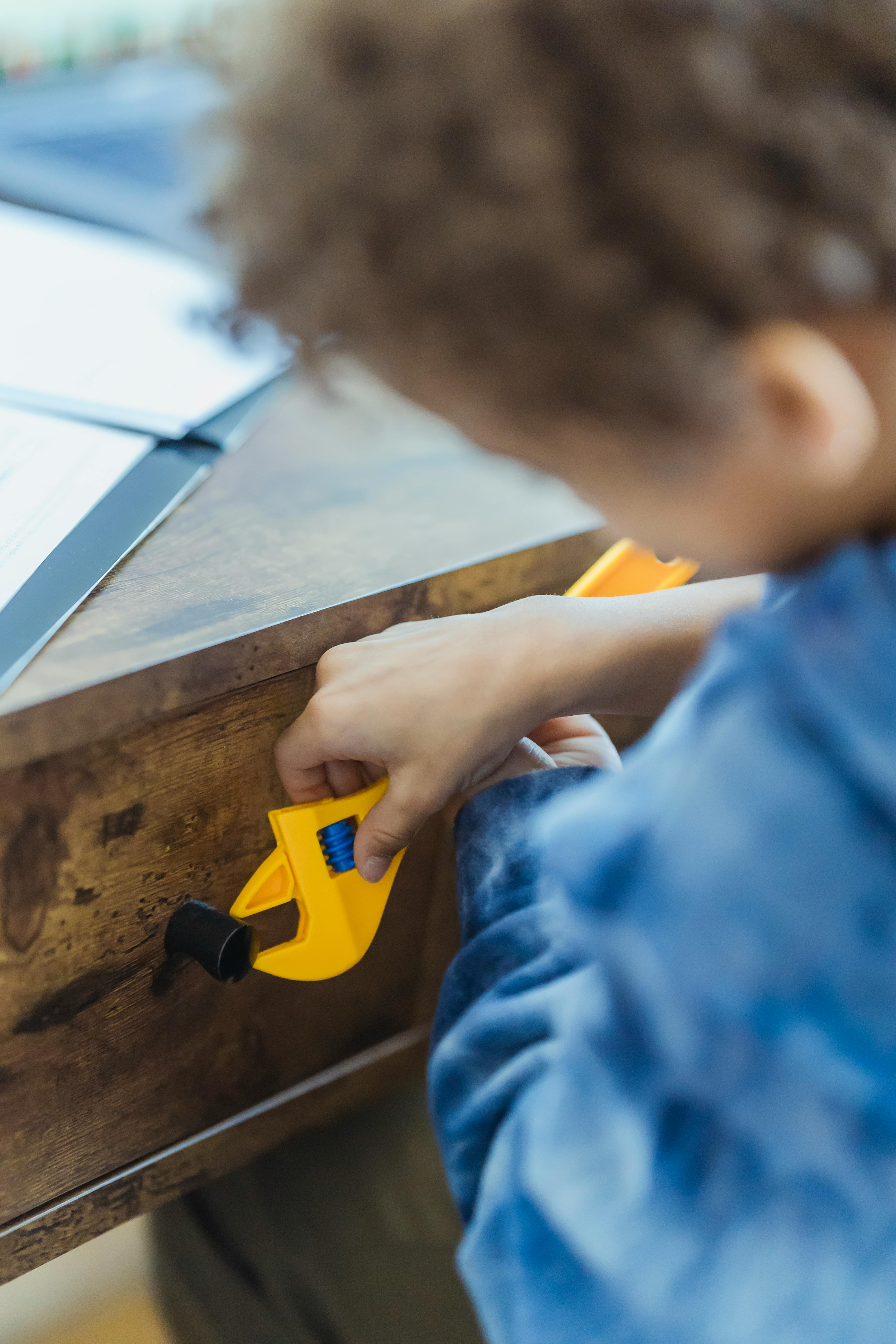 crop boy playing with adjustable wrench