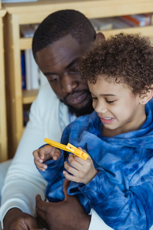 Black father with son playing with toy adjustable wrench