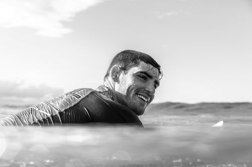 Free Black and white photo of a smiling surfer in the ocean at Gold Coast, Australia. Stock Photo