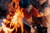 Bare hands held up to warm beside a campfire on a winter night