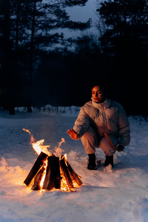 Free Man in Brown Jacket Sitting on Snow Covered Ground Stock Photo