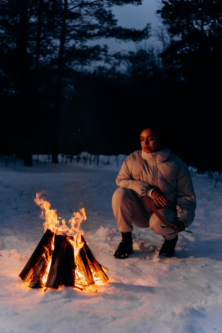 Woman In Puffer Jacket Looking At The Bonfire