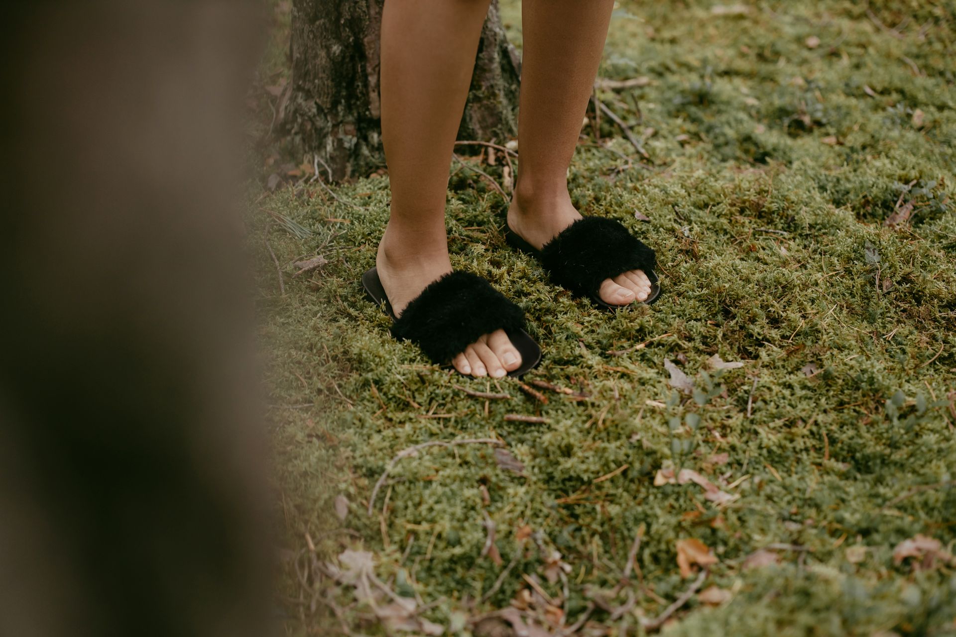 A Person Wearing Black Slippers