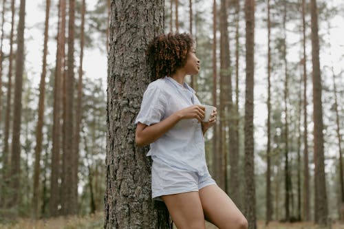 Free Woman in her Pajamas Leaning on a Tree Stock Photo