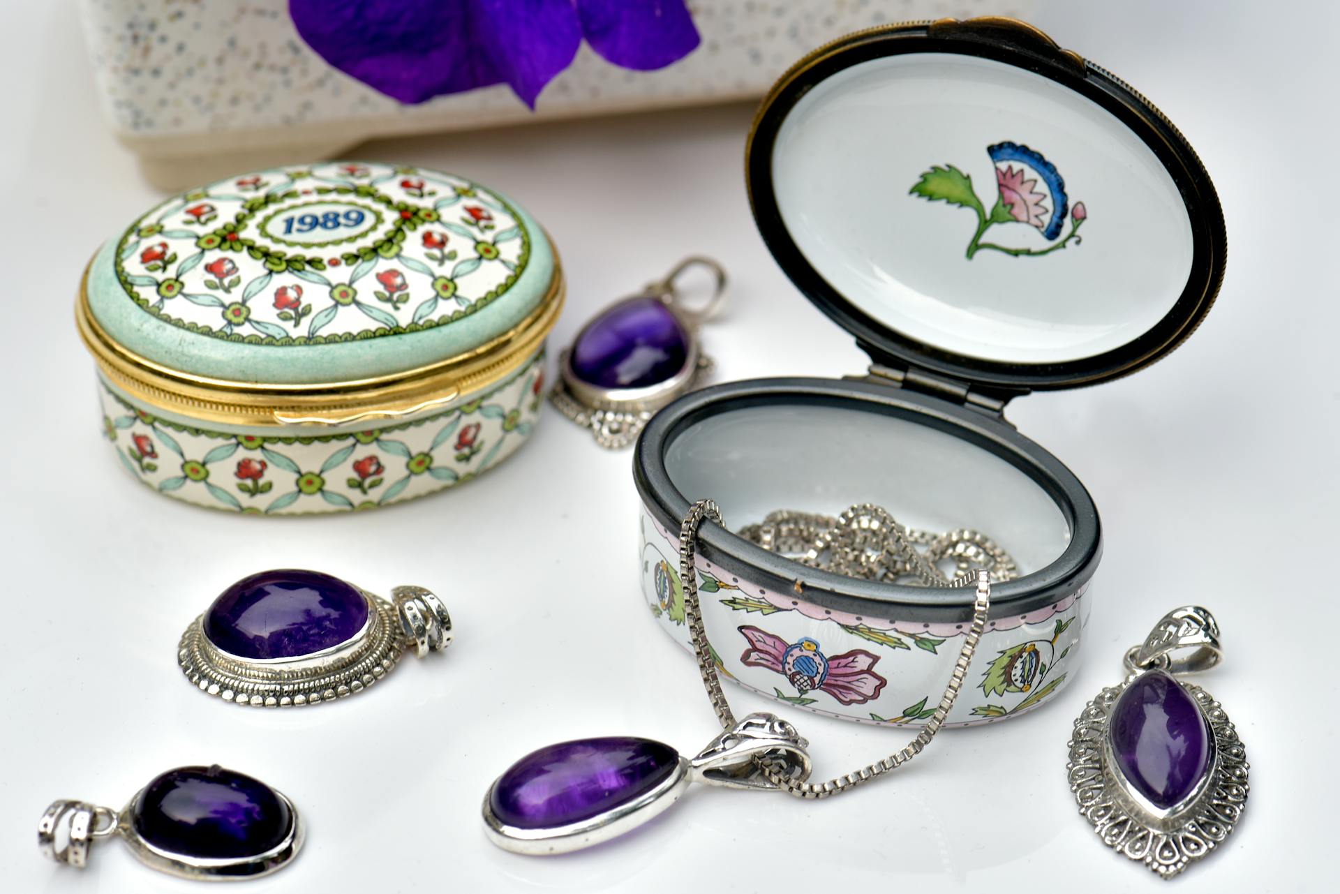 Stunning porcelain jewelry boxes with amethyst pendants and intricate designs, perfect for luxury collections.