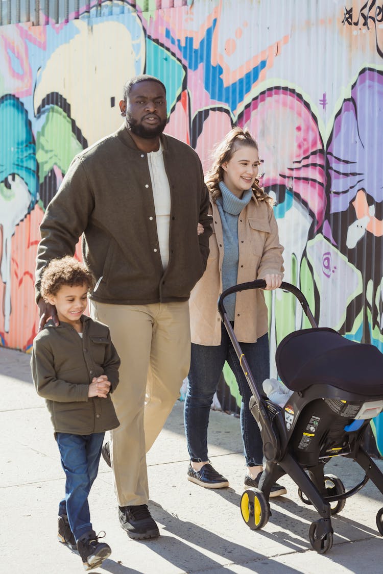 Multiracial Family With Stroller On Street