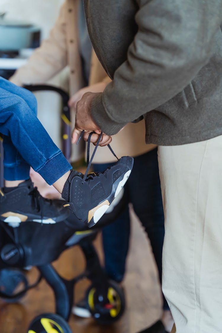 Crop Father Tying Shoe To Son