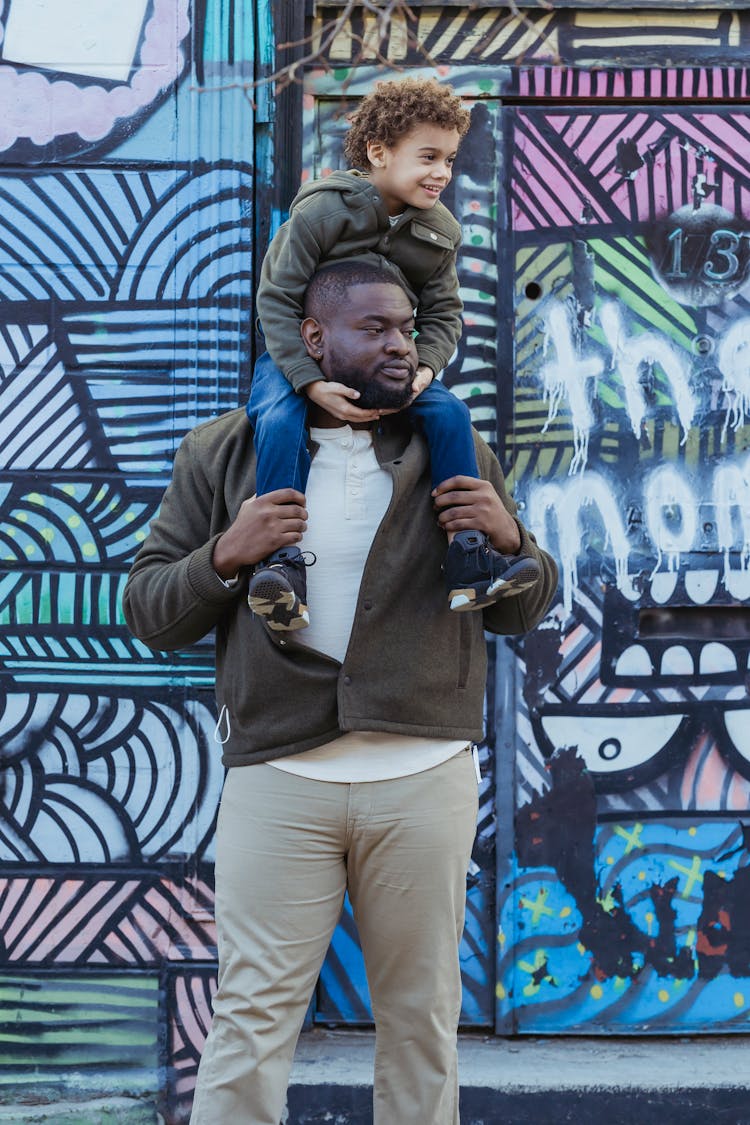 Black Father And Son Near Graffiti Wall