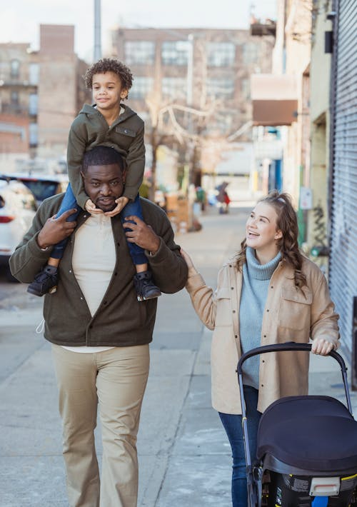 Free Multiethnic family with stroller walking in walkway Stock Photo