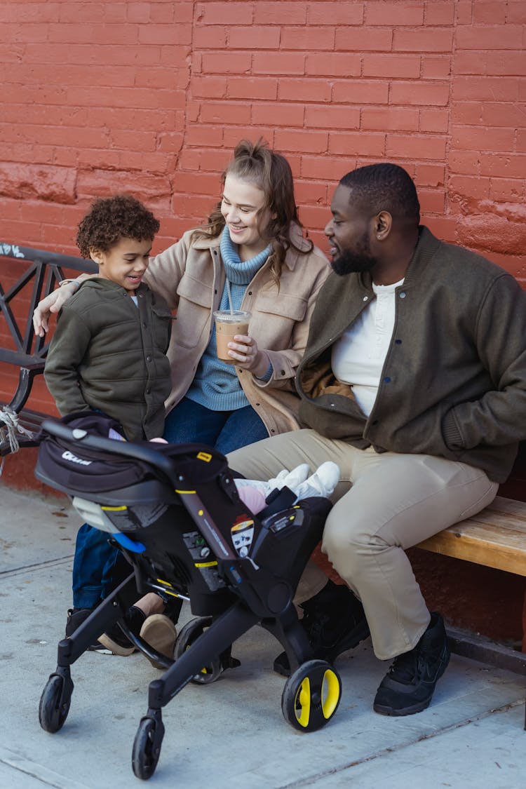 Multiethnic Family With Baby Stroller On Street