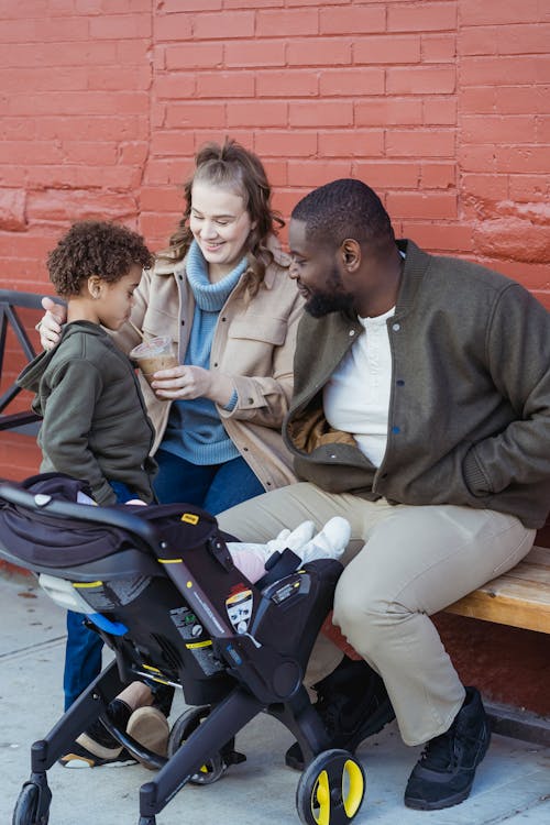 Multiethnic family gathering on bench on street