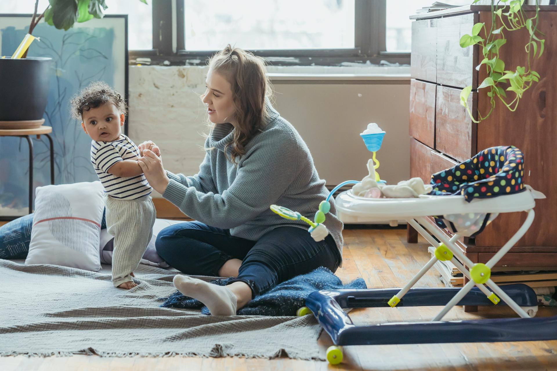 A heartwarming moment of a mother and baby bonding in a cozy home environment.