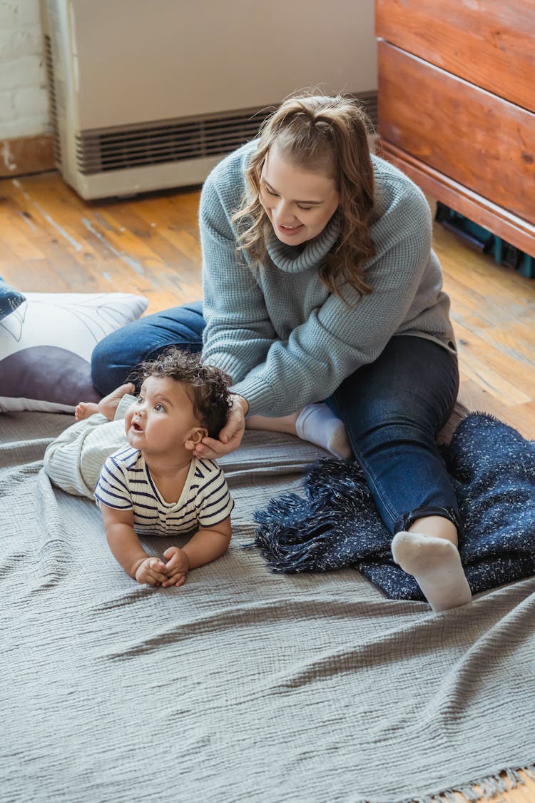 Happy Mother Playing With Cute Ethnic Baby On Floor