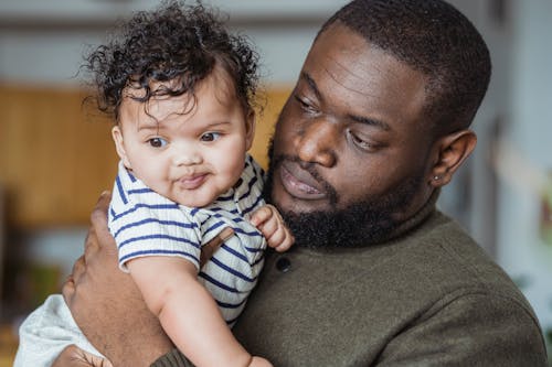 Free Black father carrying adorable little baby Stock Photo