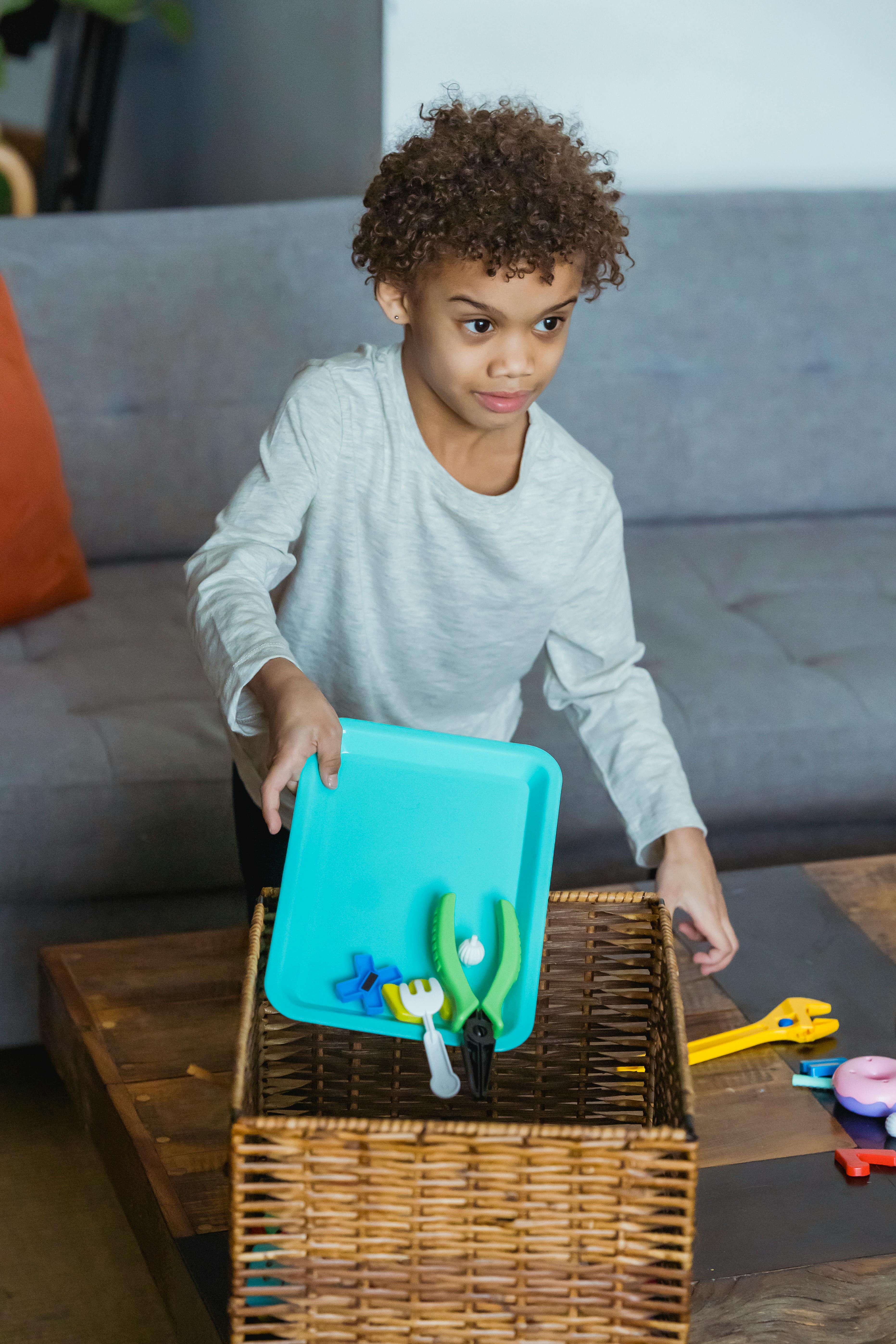 little ethnic kid playing with toy tools