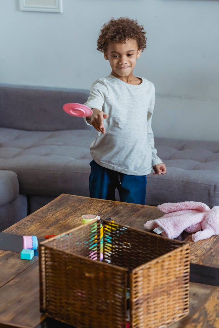 Cheerful Boy Throwing Toy In Braided Box