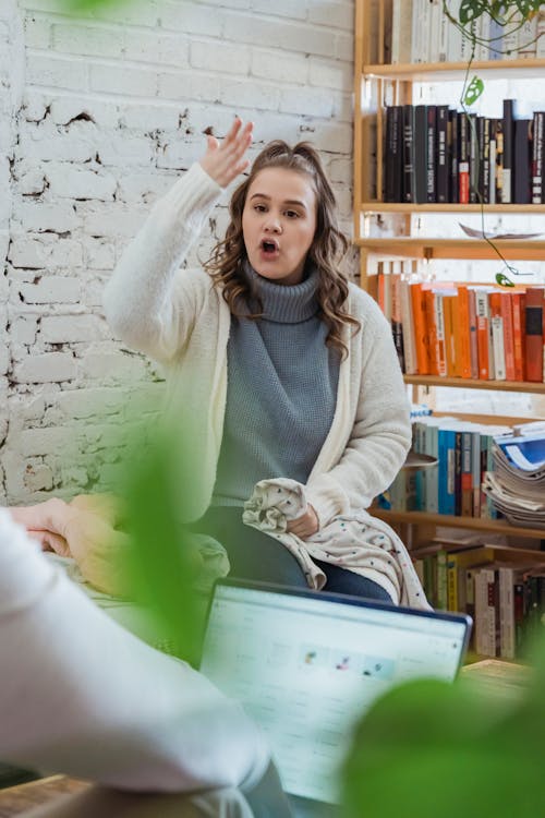 Free Annoyed woman emotionally shouting at husband and proving opinion to partner while man browsing laptop and ignoring Stock Photo