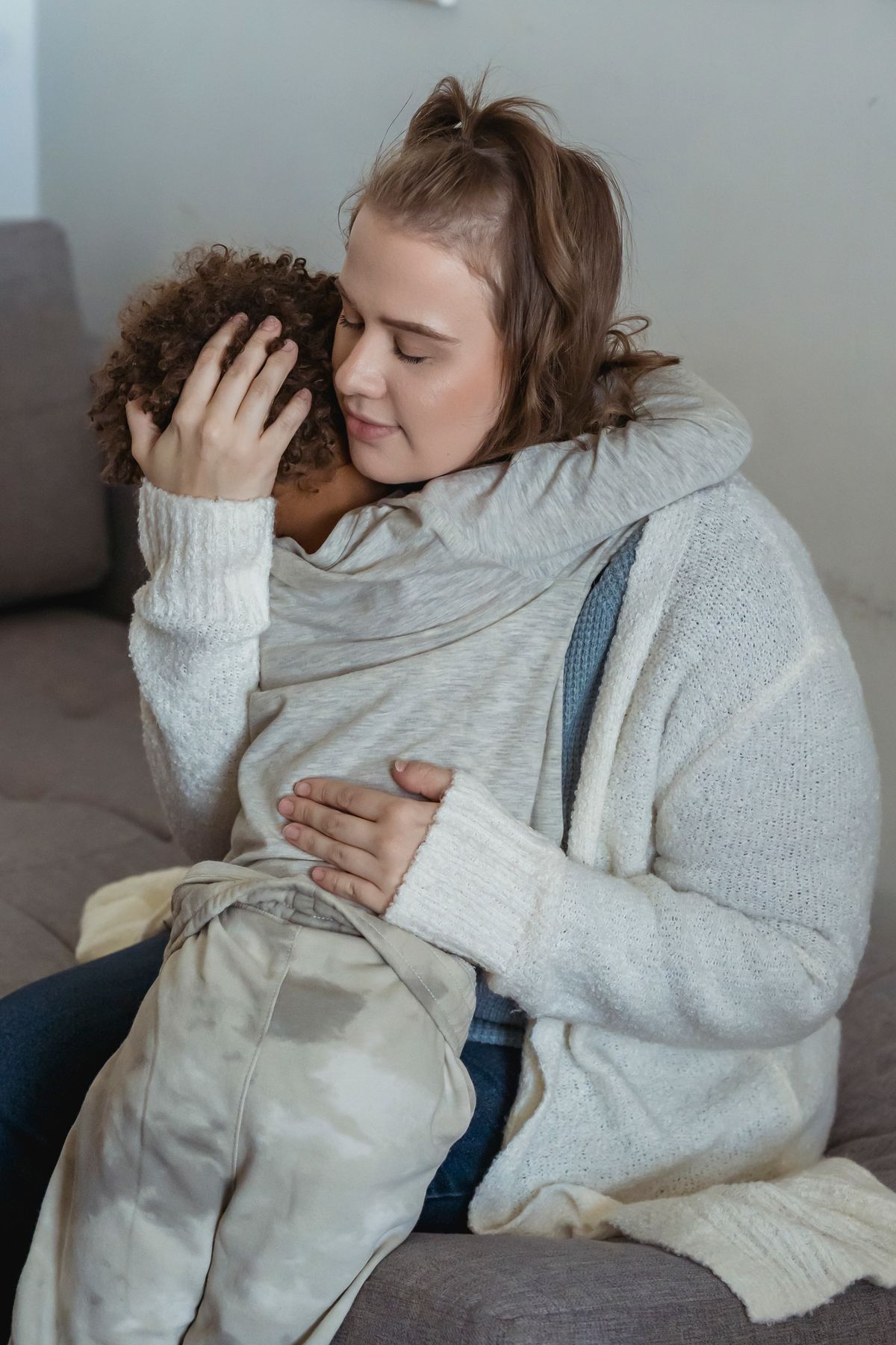 A mother comforting and embracing her child at home