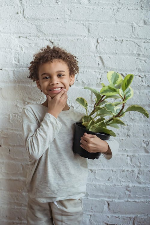 Smiling black boy with flowerpot