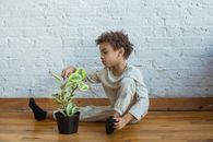 Calm black boy with flowerpot