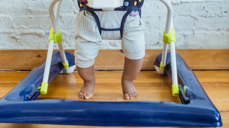 Crop Black Baby Sitting In Walker