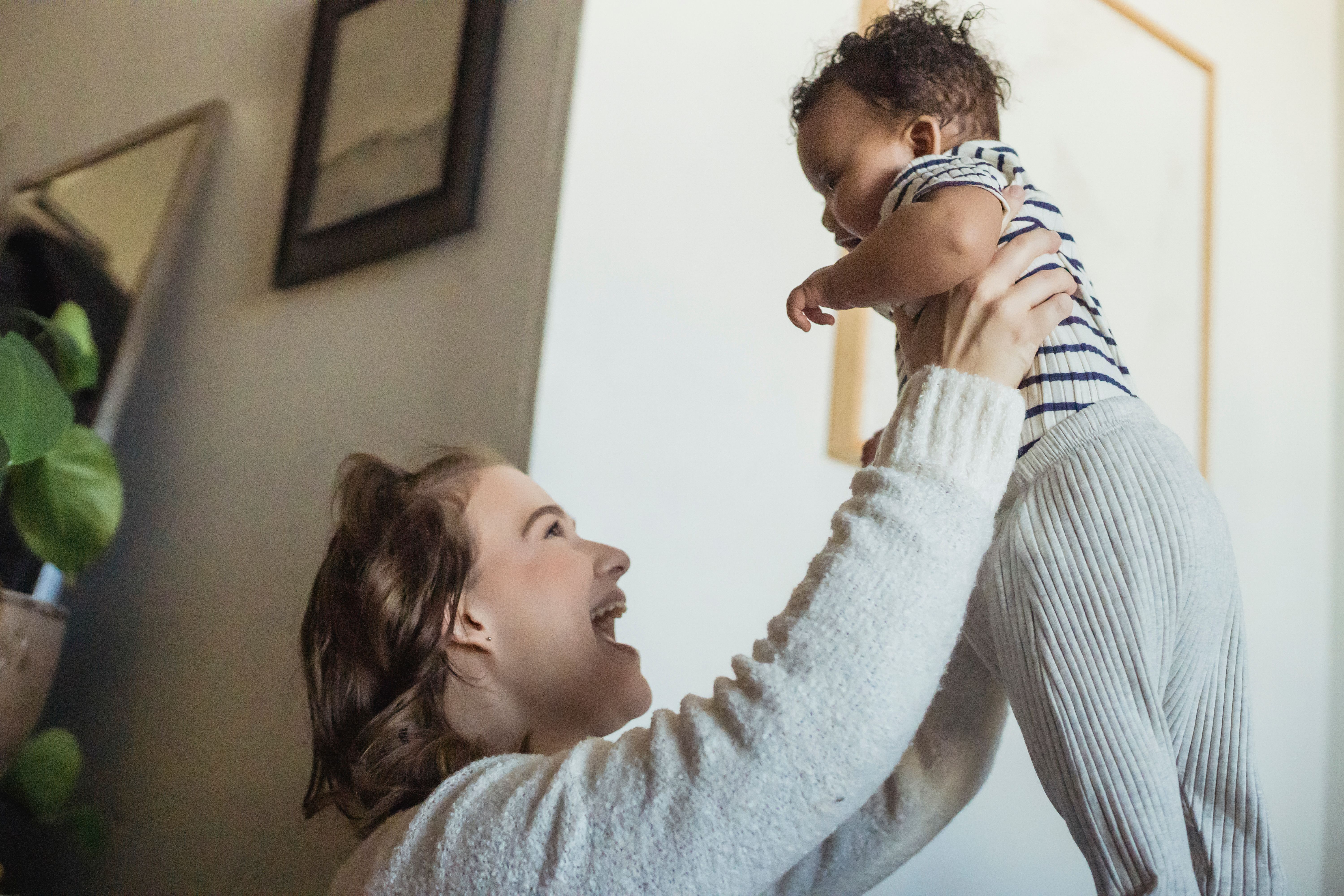 Mother lifting her baby during a joyful moment at home