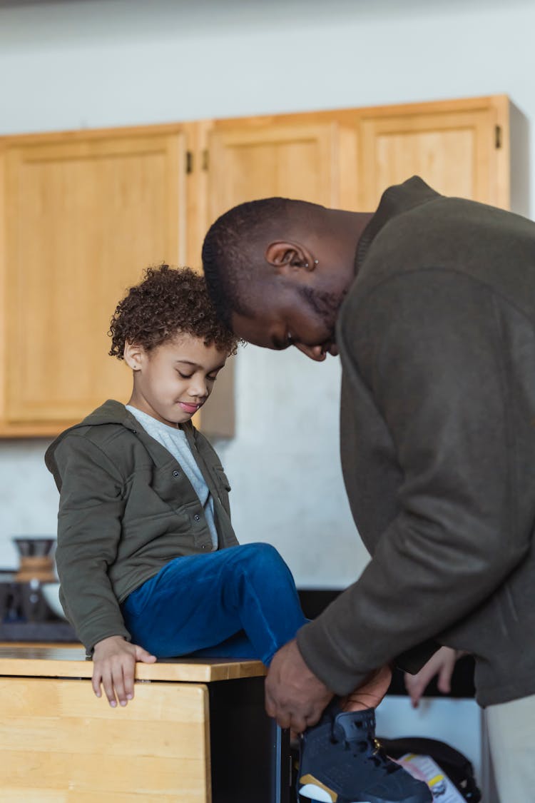 Father Tying Up The Shoe Of His Son