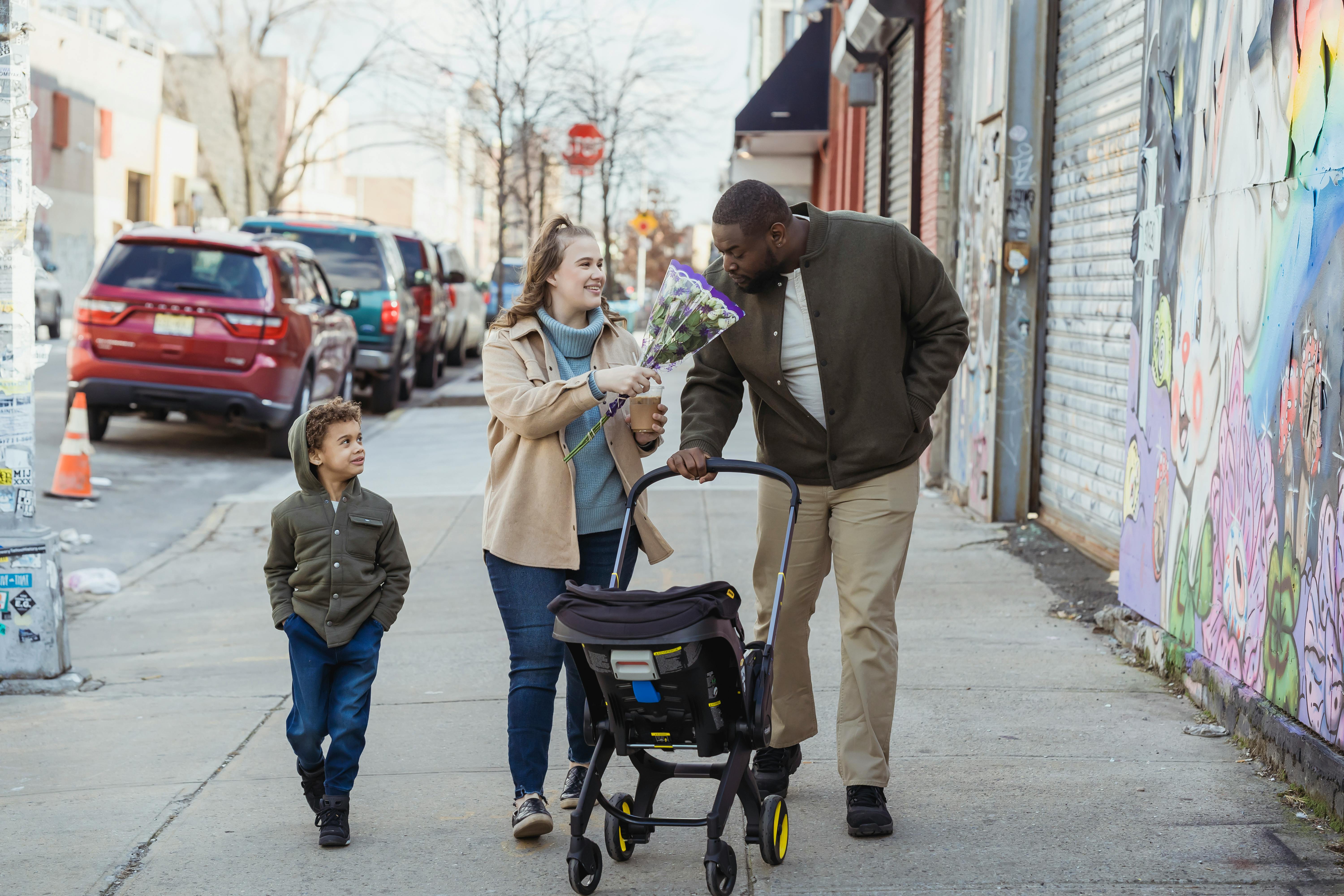 A joyful family strolls down a city sidewalk, embracing quality time and togetherness.