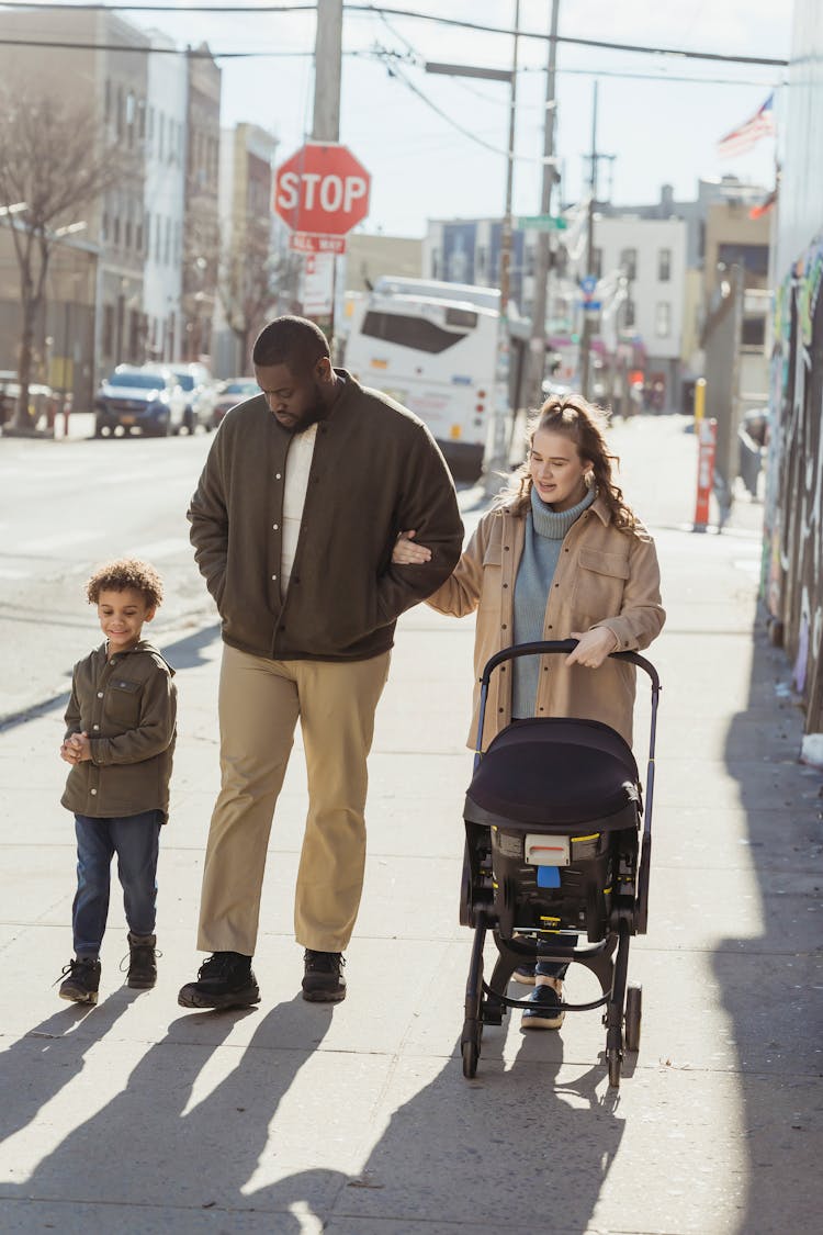 Happy Family Walking On The Sidewalk