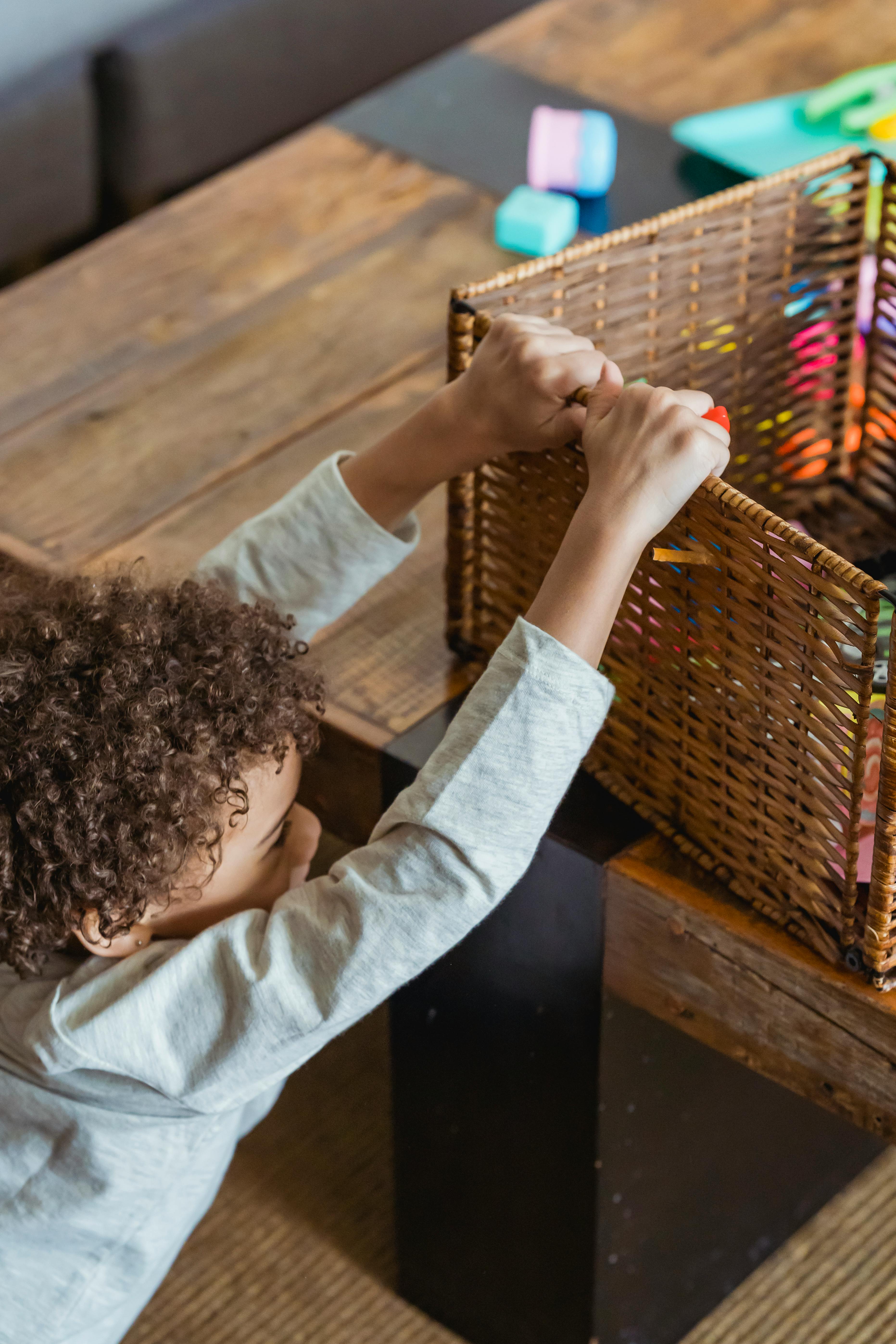 african american kid near table with toy box in room