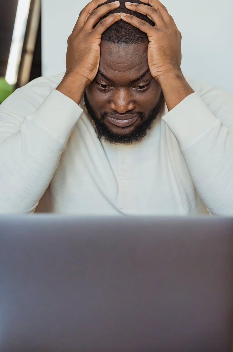 Sad Black Man With Hands On Head Near Laptop