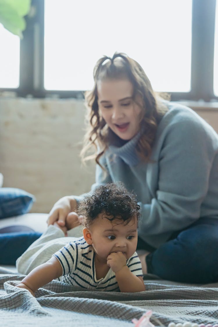 Mother Playing With Ethnic Baby On Blanket On Floor