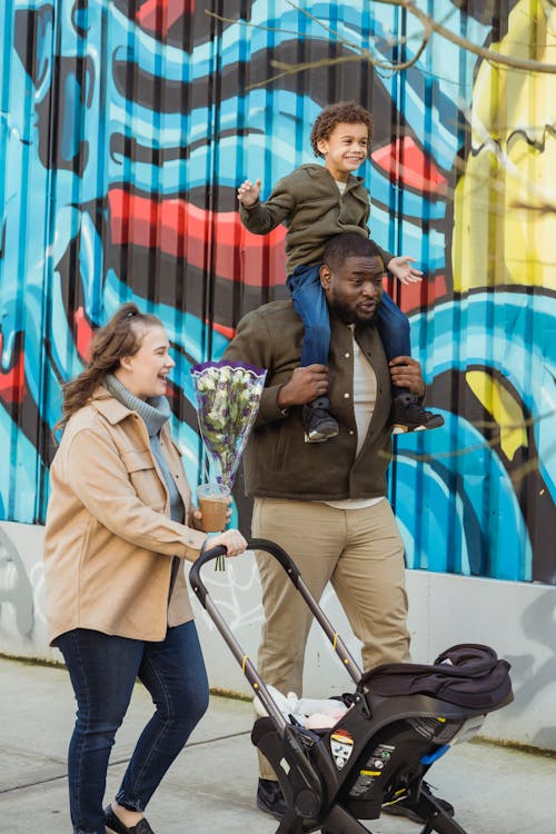 Joyful multiethnic family walking together on city street