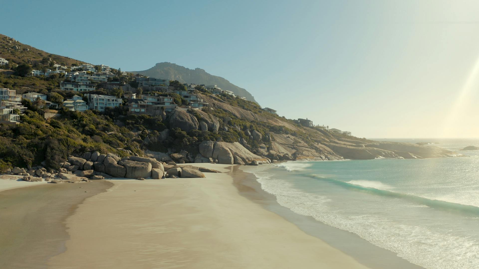 Stunning beachfront view of Cape Town with sandy shores and ocean waves.