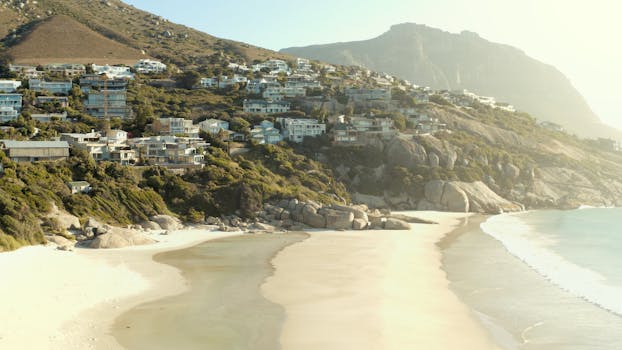 Aerial view of luxurious beachfront homes in Cape Town with stunning coastal scenery.