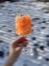 Crop person with glass of tangerines in nature