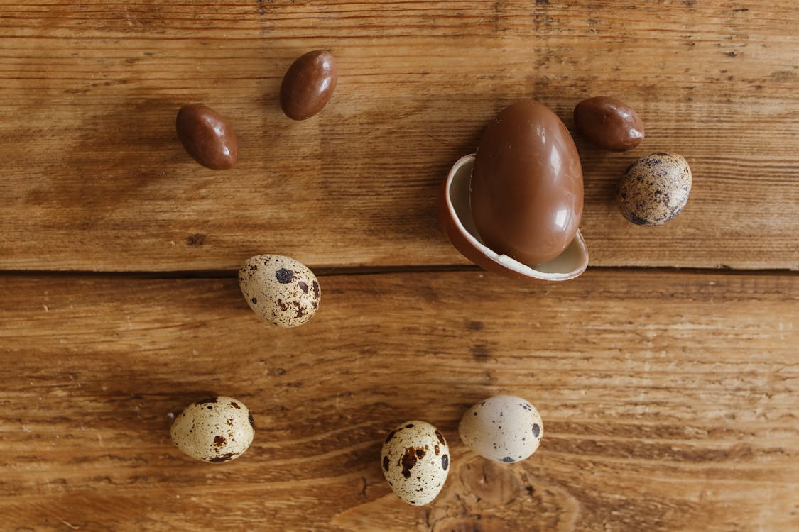 Chocolate Shaped Eggs and Quail Eggs on the Wooden Surface