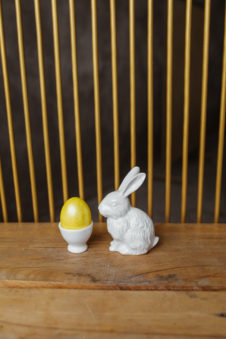 Porcelain Rabbit Sculpture Near A Yellow Egg 