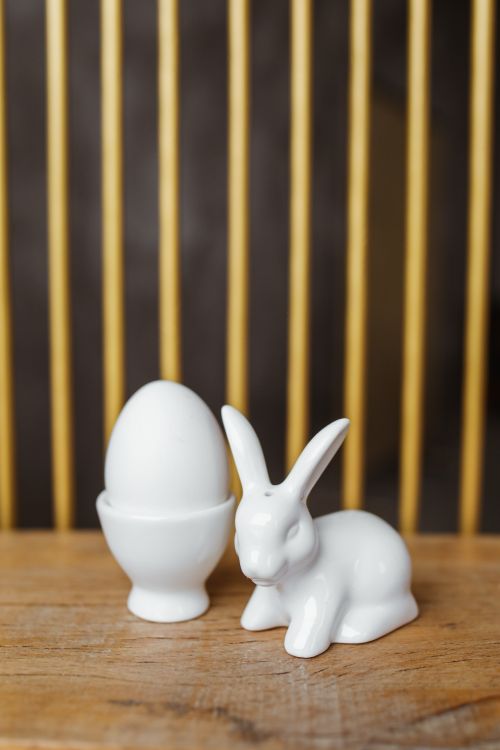 Free Porcelain rabbit and egg decor on wooden surface, perfect for Easter themes. Stock Photo
