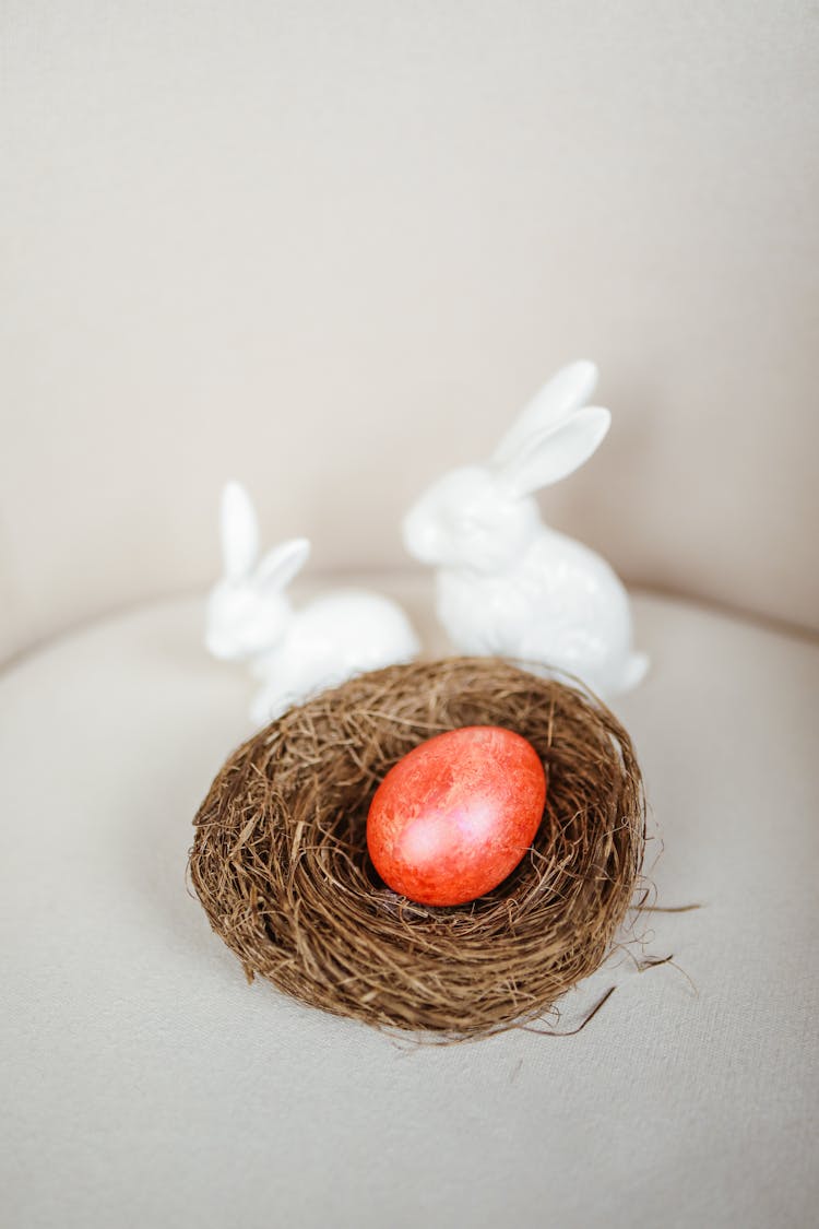 Chocolate Egg In The Nest Beside The Ceramic Figurines