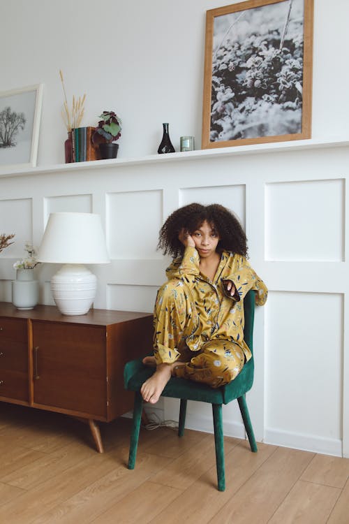 Free Woman in Yellow Pajama Sitting on a Chair Stock Photo