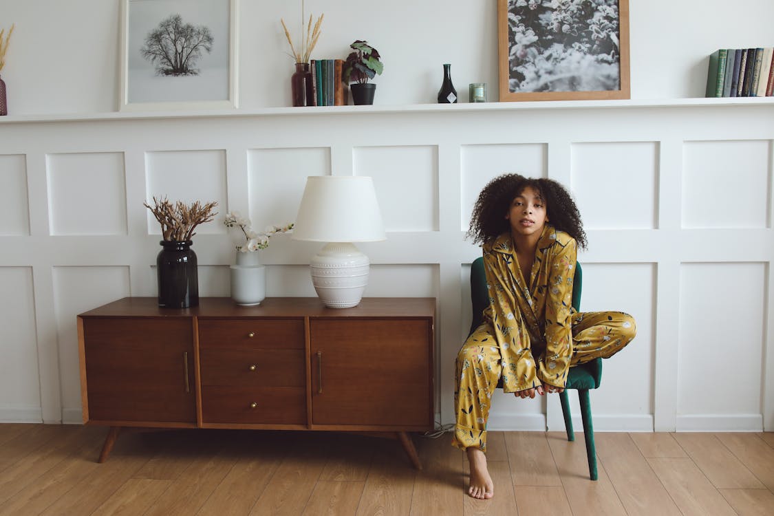 Free Woman in Yellow Sleepwear Sitting on a Chair Stock Photo