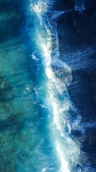 A stunning aerial view showcasing turquoise ocean waves crashing, capturing the essence of summer.