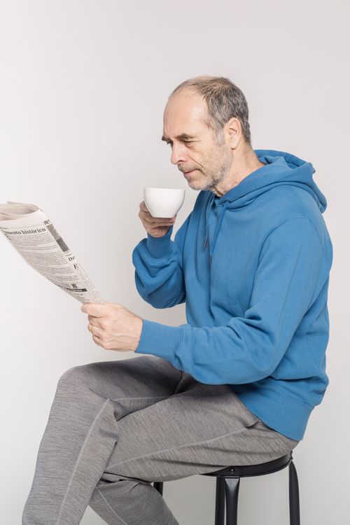 Free Senior man enjoying a relaxing moment with coffee and newspaper indoors. Stock Photo