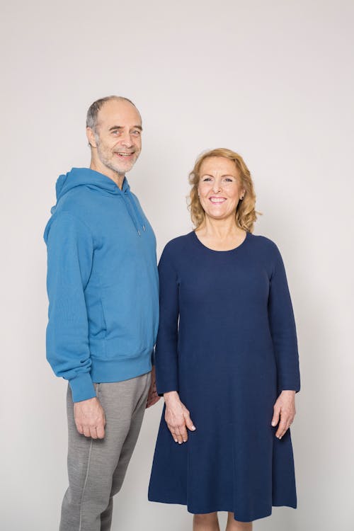 Man in Blue Long Sleeve Shirt Beside Woman in Blue Dress