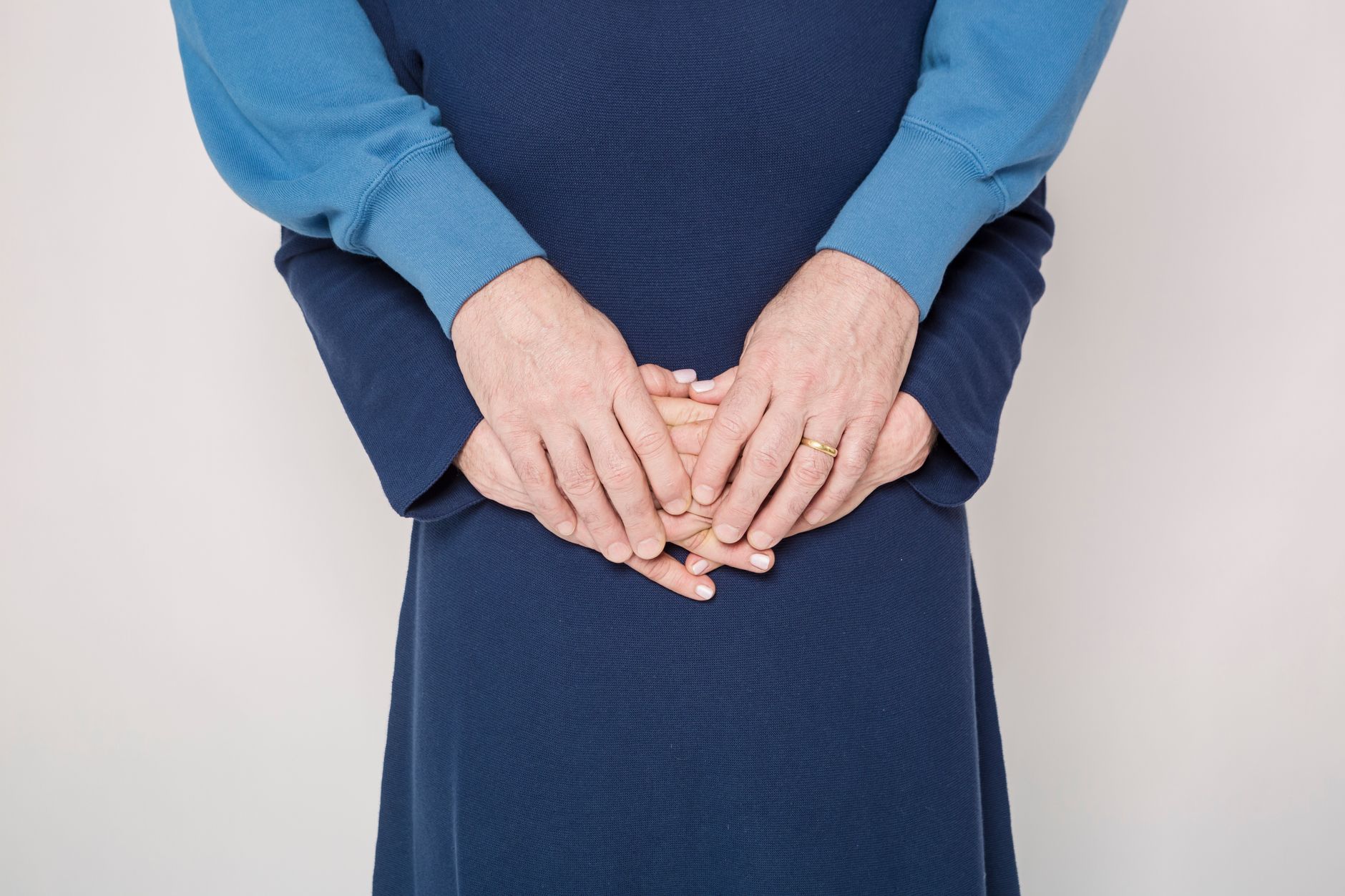 Close-up of an elderly couple embracing and holding hands in matching blue outfits.