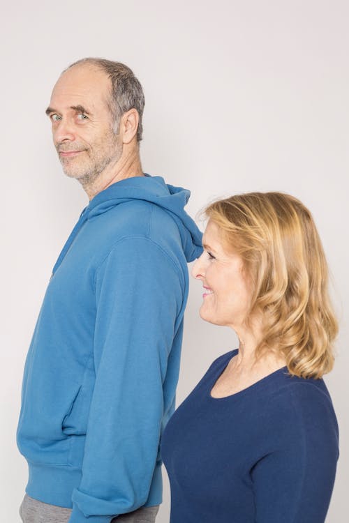 Man in Blue Jacket Beside Woman in Blue Shirt