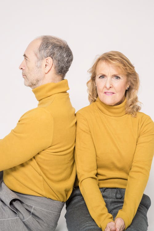 Man in Yellow Sweater Sitting Beside Woman in Yellow Sweater