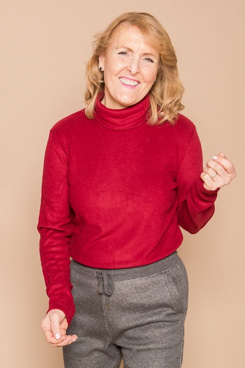 Smiling Woman in Red Sweater and Gray Pants